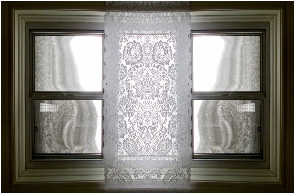 window with lace curtain and snow pile